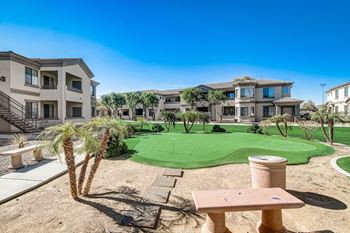 A putting green in the middle of an apartment complex with buildings